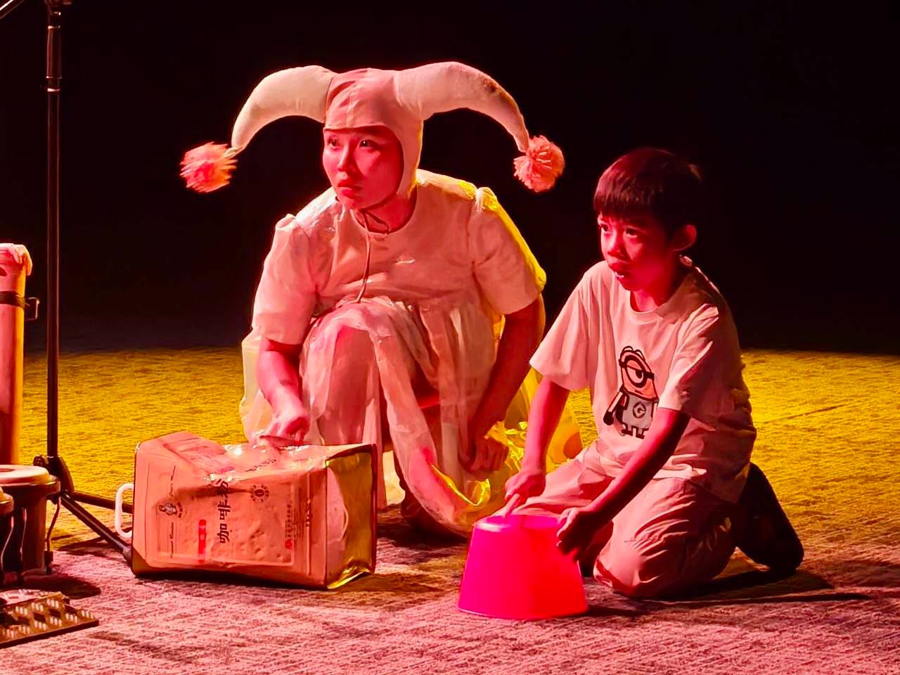Jester performer with child participant on stage