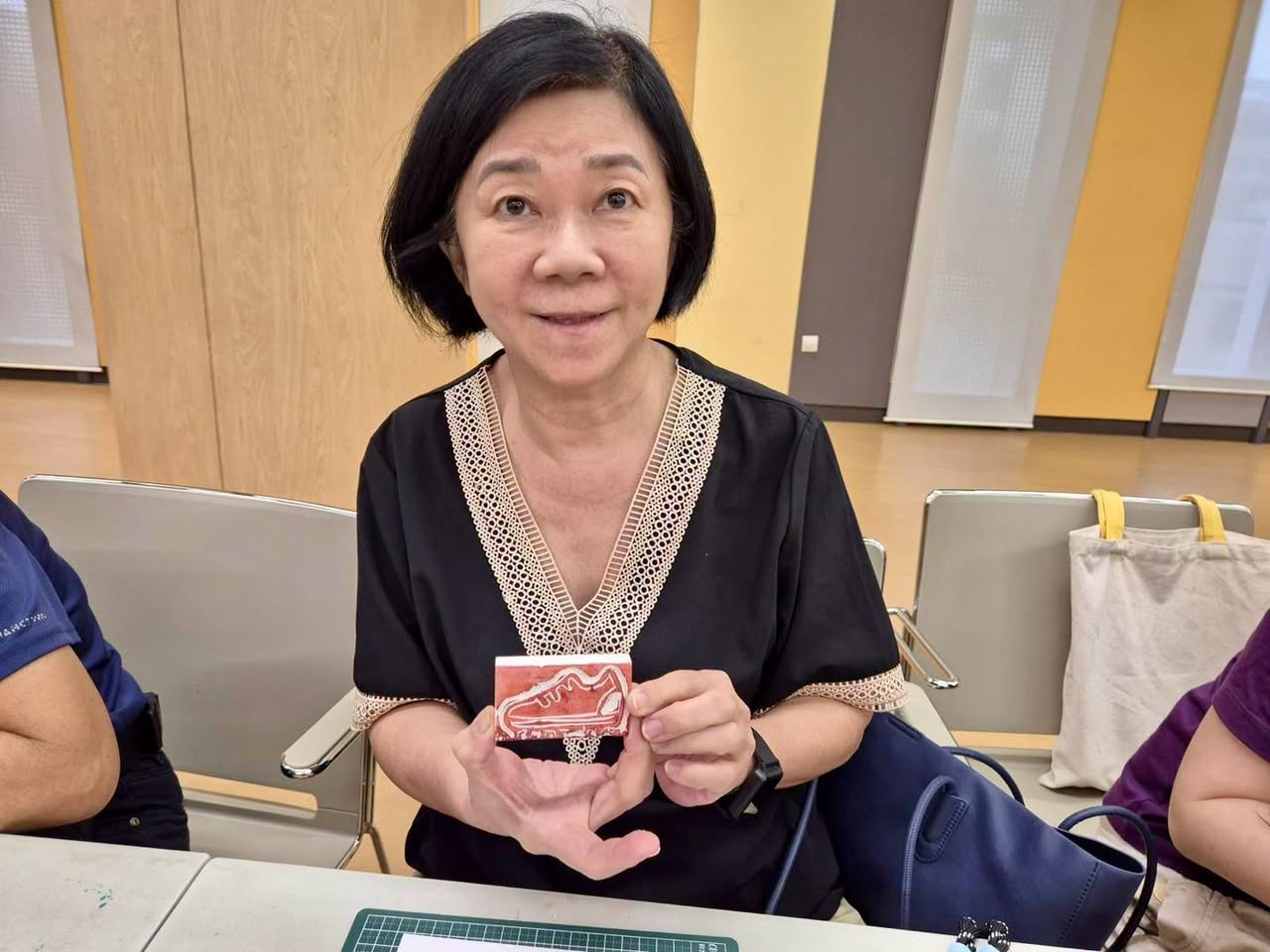 Participant holding a stamped card with a red shoe illustration