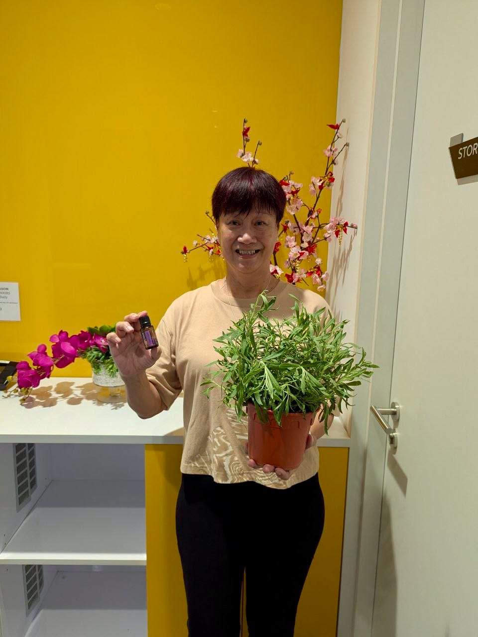 Participant holding essential oil and potted plant at the workshop