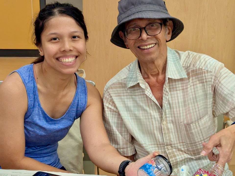 Two participants seated at the glass painting workshop