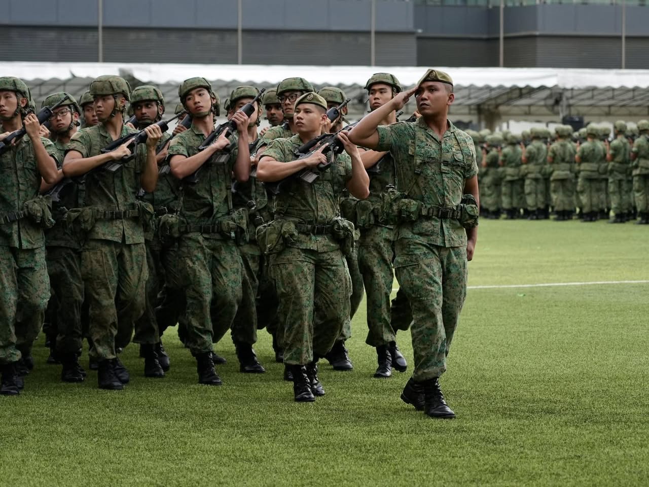 A family embracing a newly graduated recruit, filled with pride and joy.