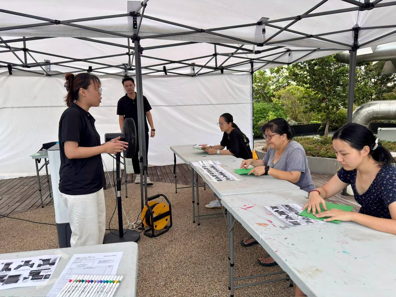 Workshop participants working with paper cutouts at folding tables