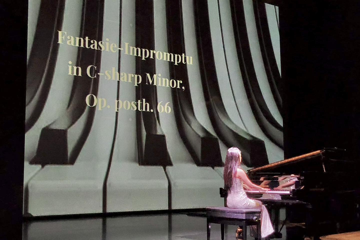 Pianist Churen Li interacting with young audience members on stage.