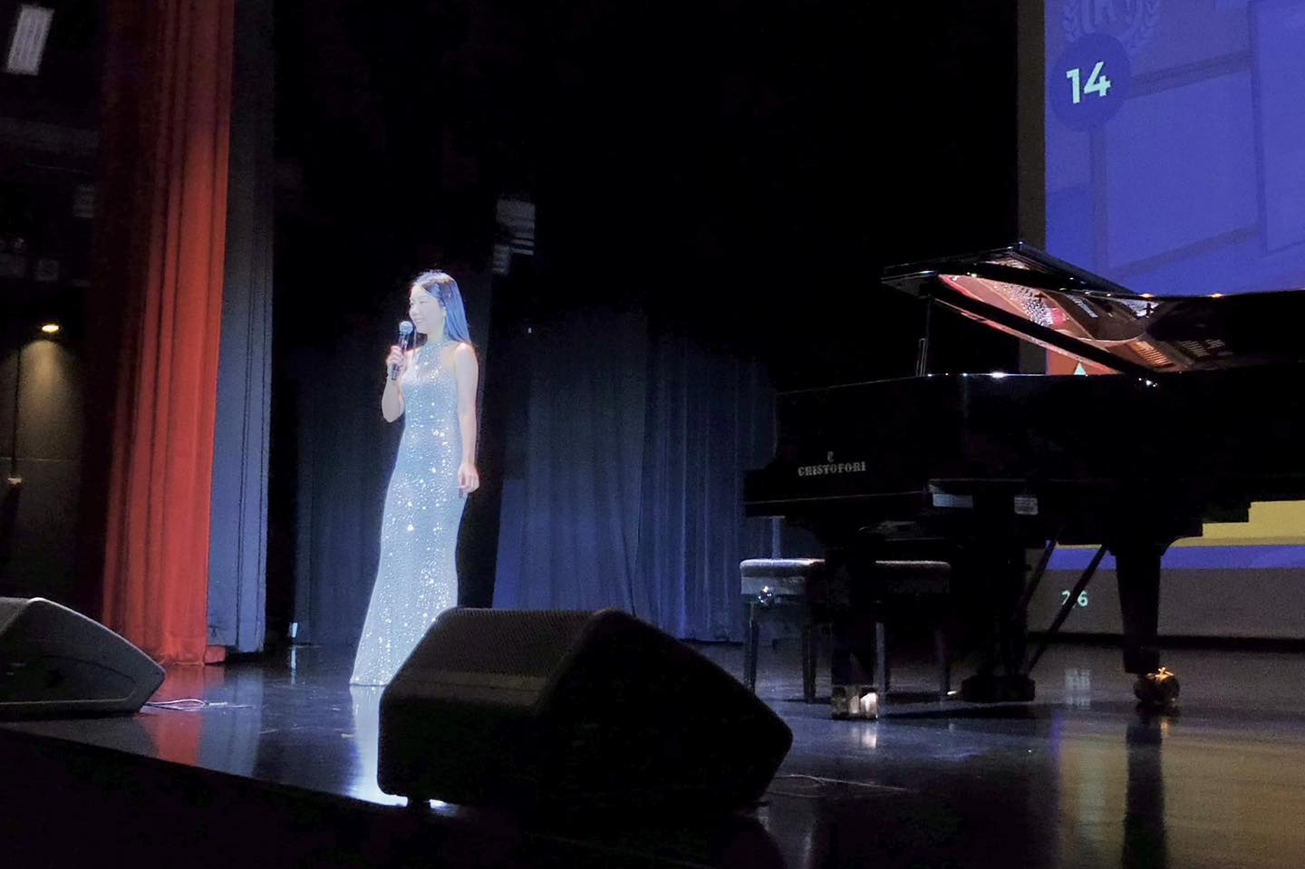 A child participating in an interactive activity on stage, surrounded by adults.