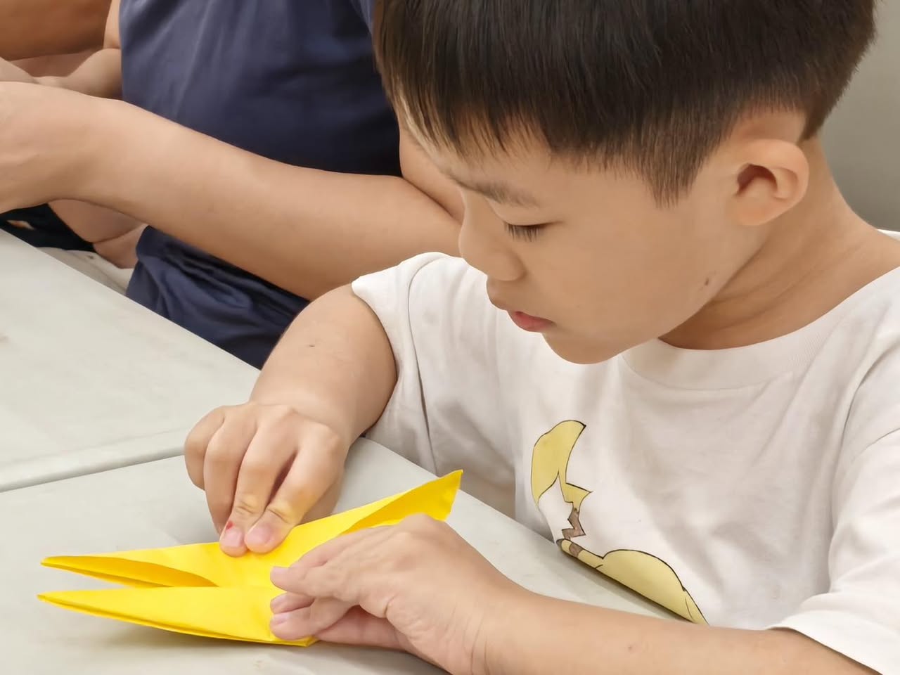 Participants focused on their paper folding projects during the origami session.