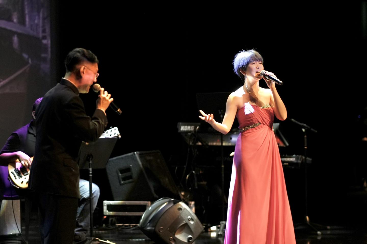 A wide shot capturing the stage and the enthusiastic audience at the Festive Arts Theatre.