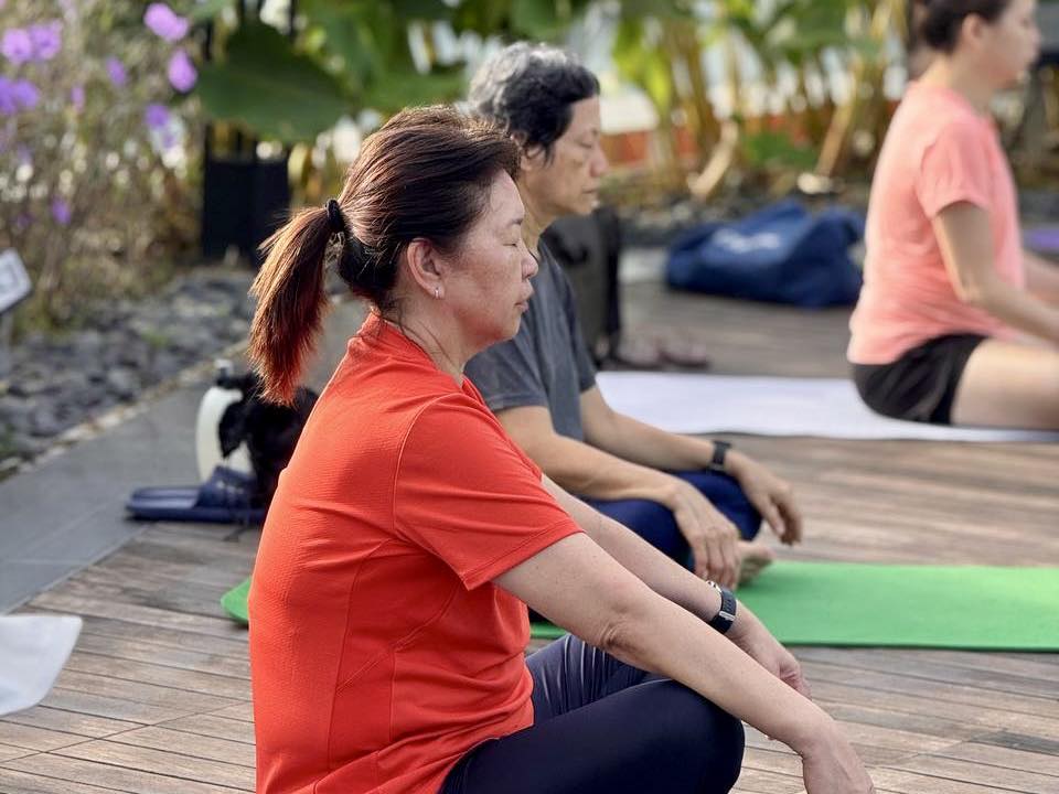 Yoga participants stretching in an outdoor garden setting