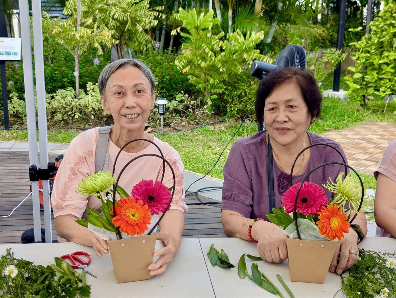 An instructor demonstrating a floral technique to eager participants
