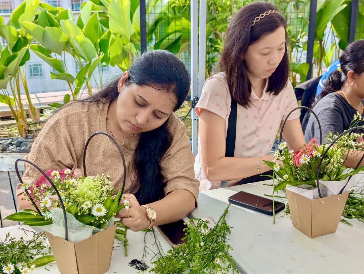 Participants engrossed in creating floral arrangements at the workshop
