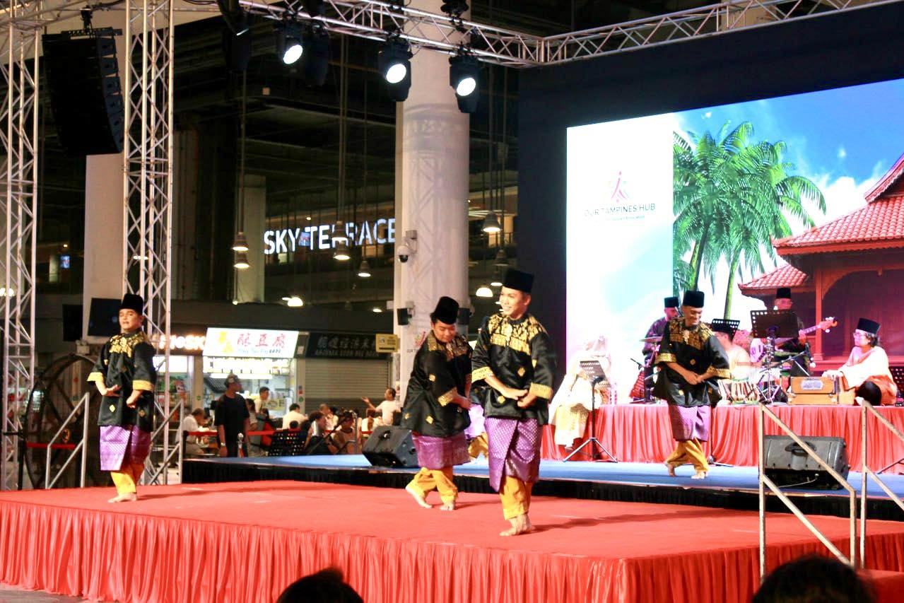 Performers in vibrant traditional Malay attire dancing gracefully on stage at Malam Tari Irama Melayu