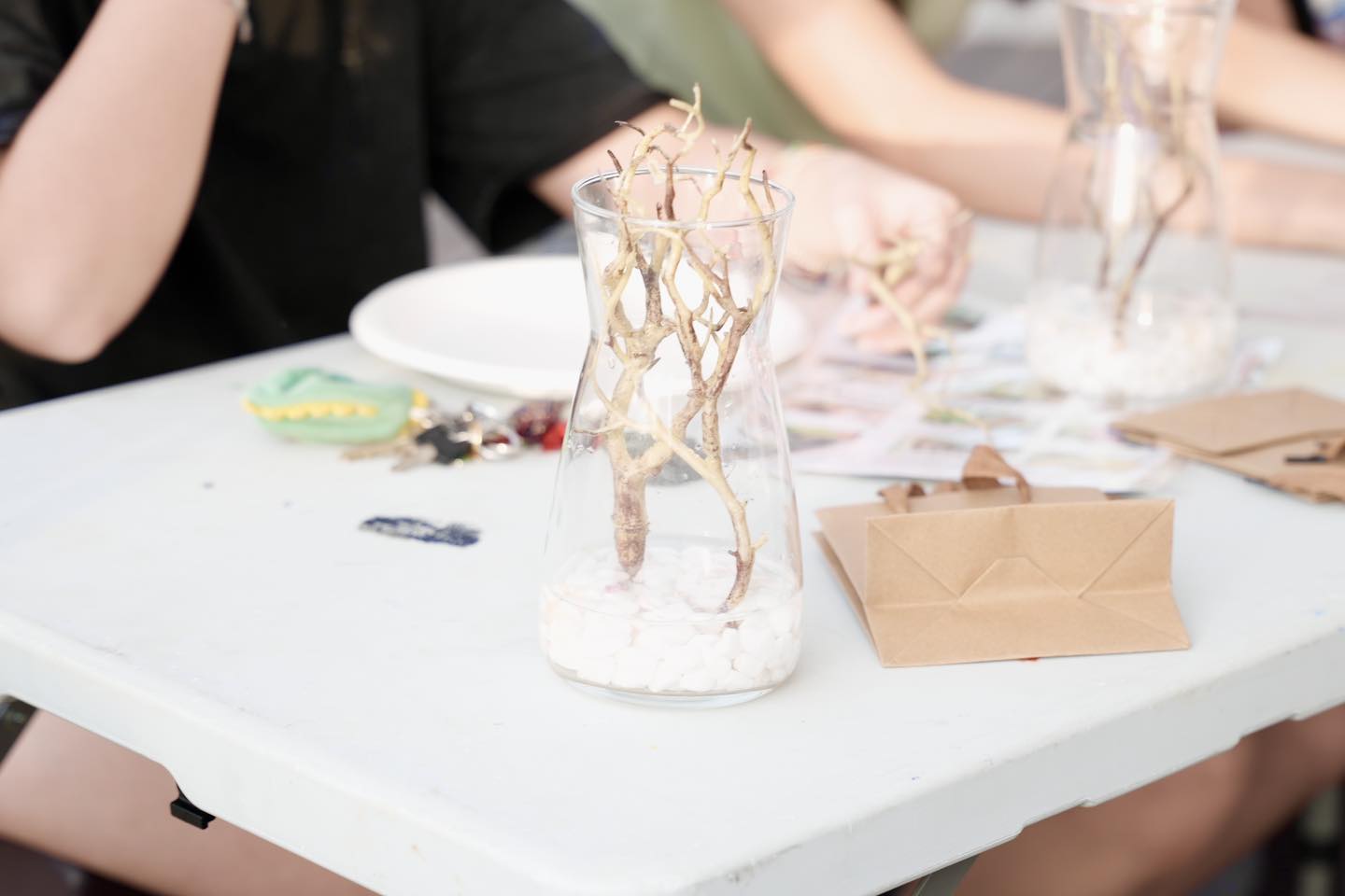 Close-up of hands gently arranging elements in a miniature terrarium.