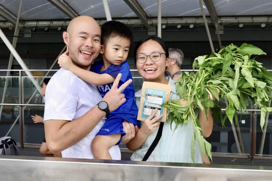 Children and adults harvesting fresh vegetables in the community garden.