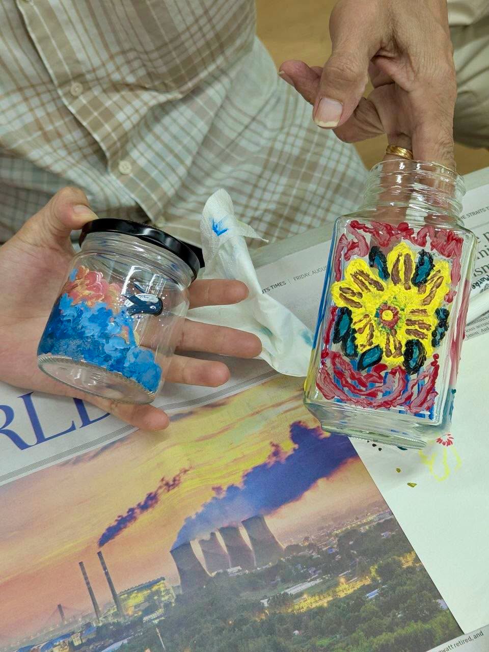 Two hand-painted glass jars with blue abstract and yellow flower designs