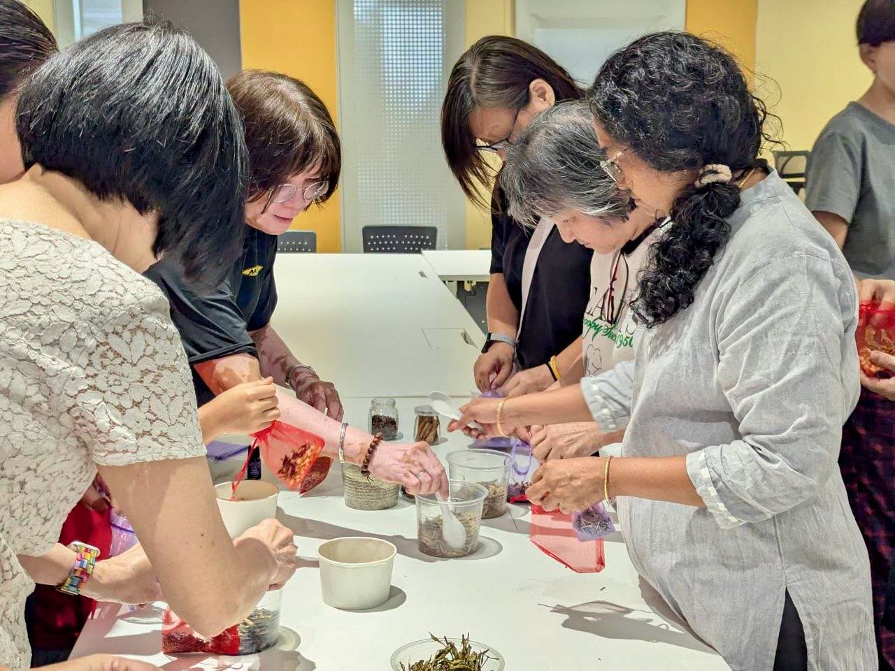 Participants filling bags with loose leaf tea at the workshop