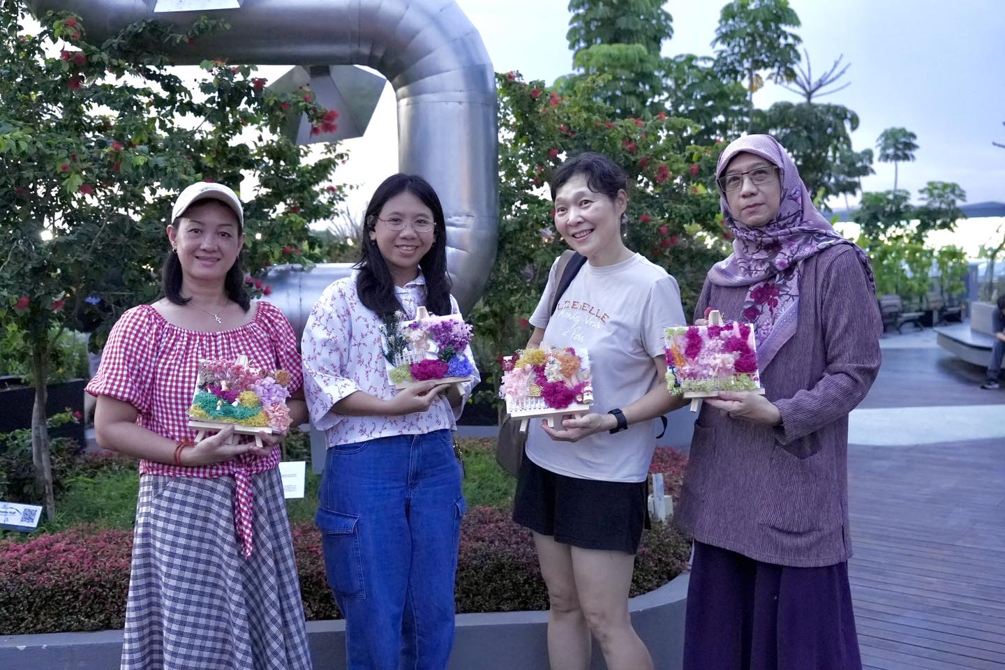 Happy participants showcasing their finished preserved plant art