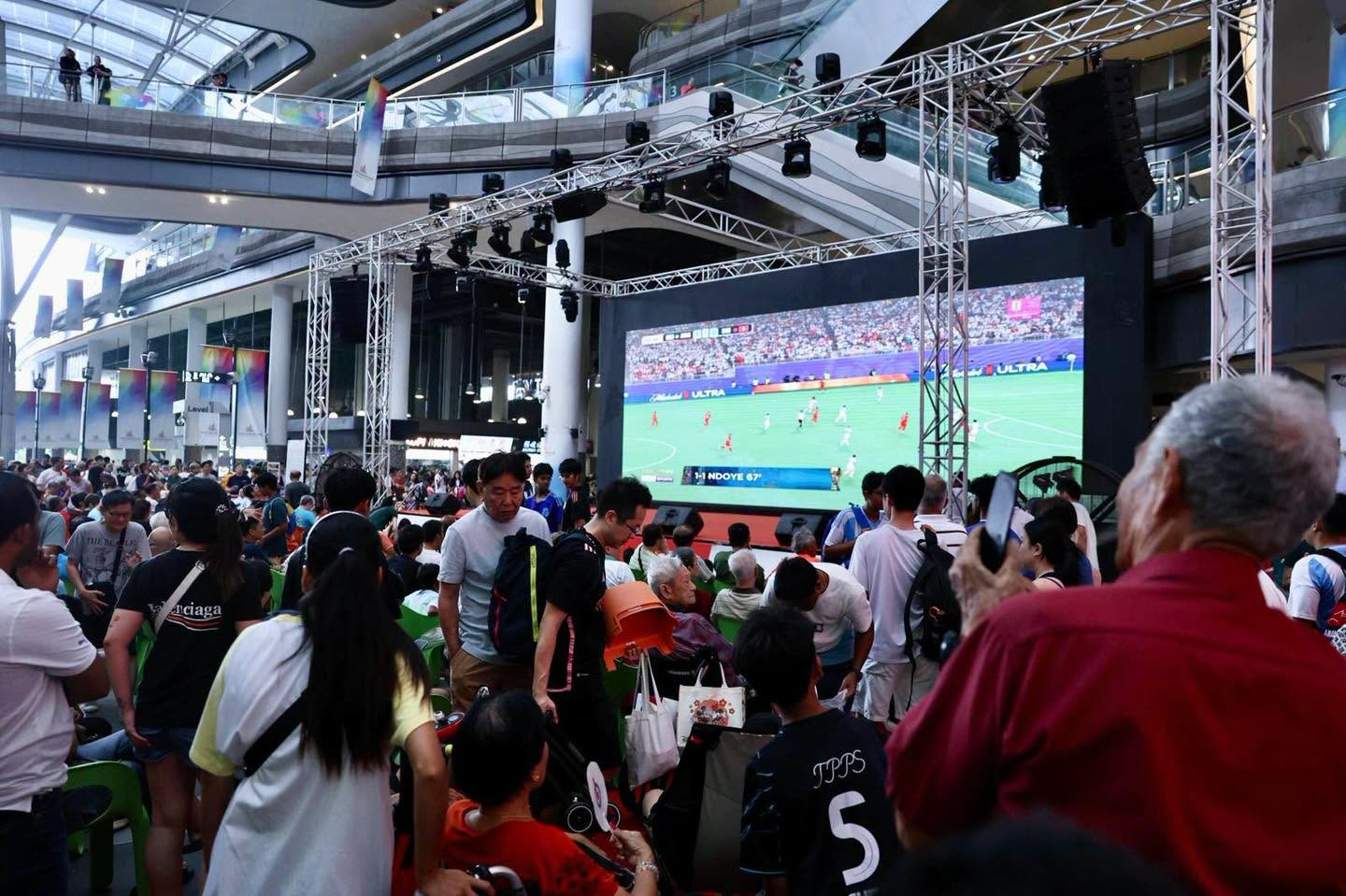 Football match broadcast on large screen at Our Tampines Hub atrium