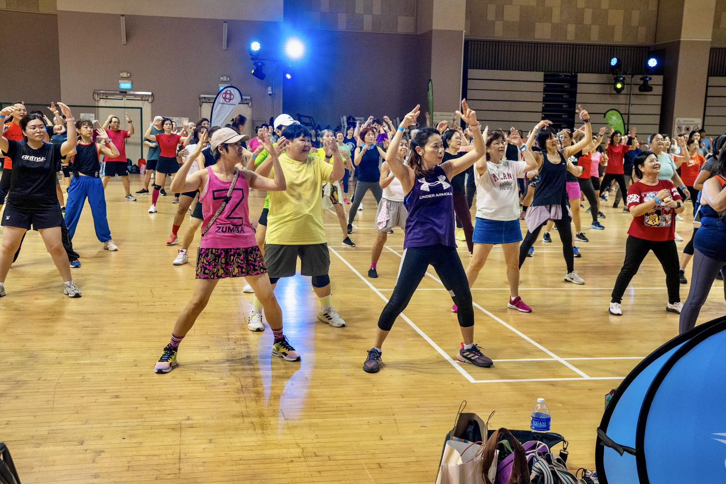 Overview shot of the energetic SG60 Fitness Bonanza event at the community auditorium