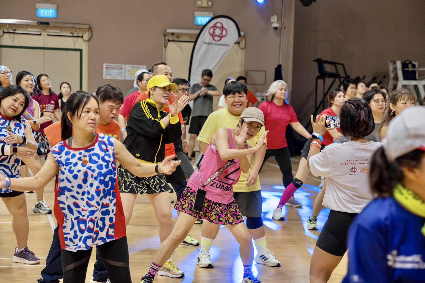 An instructor leading a vibrant BollyBeats workout with enthusiastic participants