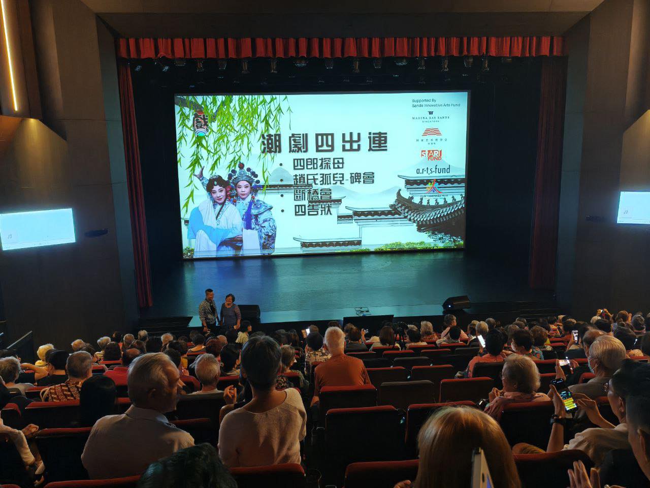 A group photo of Teochew opera performers and event staff on stage at Our Tampines Hub.