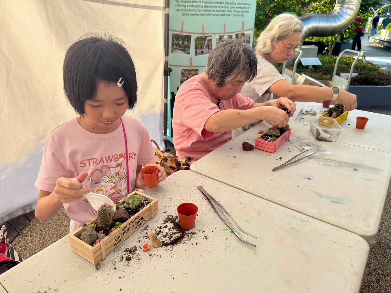 Participants arranging succulents in CALIFORNIA GARDEN planter boxes