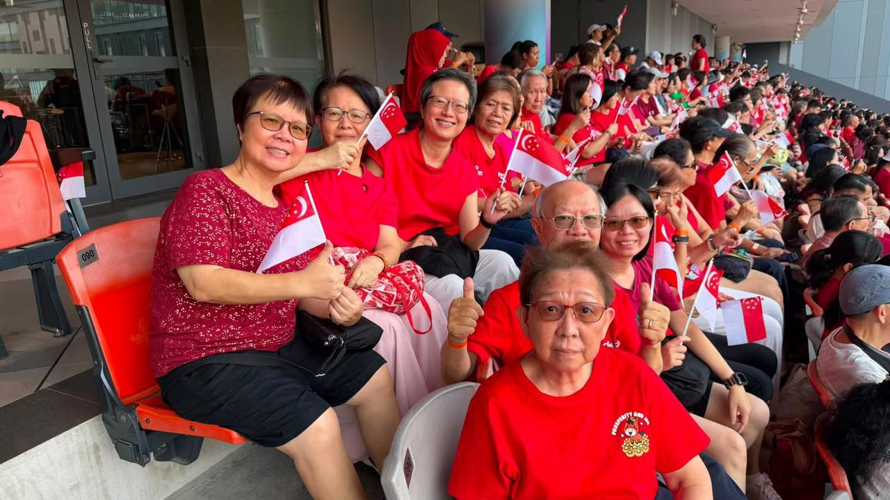 Crowd waving Singapore flags outside Our Tampines Hub